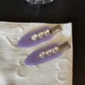 Primo piano di fermagli per capelli viola con strass a cuore e clip metalliche. - Fermaglio Senza Traccia Strass Cuore Viola