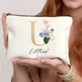 Bolsa de maquillaje blanca personalizada con letra dorada U y flores, ideal viaje. - Estilo U