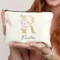 Vista detallada del neceser personalizado con letra floral y nombre impreso en la bolsa. - Estilo R