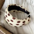 Primer plano detallado de la diadema ancha beige vintage con lunares abstractos marrones. - Beige