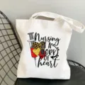 Nahaufnahme des Pflegethemen-Drucks auf der Segeltuchtasche mit strapazierfähigen Nähten. - Arbeit des Herzens Slogan Stil / L