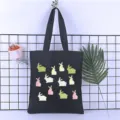 Detail view of black canvas tote bag featuring cute cartoon rabbit prints and sturdy shoulder straps. - Style 22 / 35*40cm