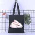 Detailed view of a black canvas tote bag featuring a cute white rabbit print and durable straps. - Style 17 / 35*40cm