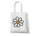 Gedetailleerd overzicht van de witte canvas draagtas met leuke zwart-gele madeliefjesprint. - Stijl 5