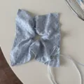 Gros plan sur chouchou à pois bleus avec bordure en dentelle délicate et nœud ruban. - Bande Carrée Nœud Ruban / Bleu