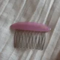 Pink acetate hair comb detail view, showing delicate metal teeth and smooth glossy surface finish. - Oval Hair Combs with Gold Label - Light Pink