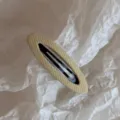 Vista dettagliata di un elegante fermaglio per capelli in tessuto a righe, accessorio chic. - Giallo Traforato Ovale BB-Righe Sottili