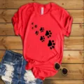 Close-up detail view of red short sleeve t-shirt with black paw print graphic design. - S / Tops / Red (Black Paw Print)