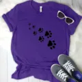 Purple short sleeve t-shirt featuring a cute black paw print graphic design, casual style. - Purple (Black Paw Print)