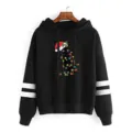 Detailed view of black hoodie featuring white sleeve stripes and cute Christmas cat graphic. - Black