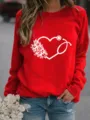 Nahaufnahme des roten Sweatshirts mit einem medizinischen Stethoskop-Herz-Blumen-Druck. - Rot