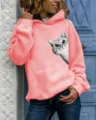 Detailed view of pink hooded sweatshirt with cute peeking cat graphic print, long sleeves. - Pink