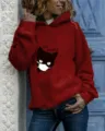 Detail shot of the wine red hooded sweatshirt featuring a cute cat graphic and long sleeves. - Burgundy