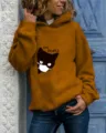Detailed view of women casual mustard yellow hooded sweatshirt featuring cute cat graphic print. - Khaki