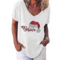 Close-up detail van wit V-hals korte mouw t-shirt met kerstmuts en Believe print. - S / Tops / Wit