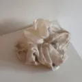 Primo piano dettagliato dello scrunchie ad acquerello, con morbido tessuto ed elastico. - Beige Albicocca