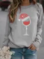 Detailed view of grey crewneck sweatshirt featuring a sparkling Christmas wine glass rhinestone print. - Gray