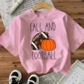 Pink short sleeve t-shirt featuring fall football and pumpkin graphic casual top for women. - S / Tops / Pink