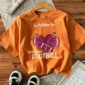 Orange short sleeve graphic t-shirt featuring fall football and pumpkin theme for women. - Orange