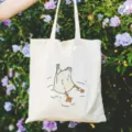 Vue détaillée d'un sac cabas en toile blanche avec imprimé de canard plongeant pour le quotidien. - Canard à l'envers