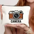 Gedetailleerd overzicht van een wit canvas cosmeticatasje met retro cameraprint en tekst. - Vintage Camera Twee