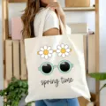 Gros plan d'un sac cabas en toile blanche avec un joli imprimé marguerite et lunettes. - 5
