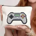 Détail rapproché de la trousse de maquillage blanche en toile avec motif manette de jeu rétro pixel. - Manette de jeu