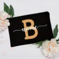 Detailed view of the customized black makeup bag featuring floral decor and custom letter design. - Letter B