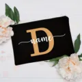 Custom letter makeup bag detail, black canvas cosmetic pouch with floral background display. - Letter D