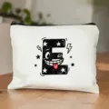 Detailopname van een wit canvas make-up tasje met een schattige cartoon letter E print design. - Letter E Stijl
