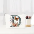 Close-up detail of the elegant letter D cosmetic pouch with floral butterfly print. - Letter D