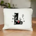 Gedetailleerd overzicht van witte cosmetictas met coole cartoon letter L print en zwarte rits. - Letter L