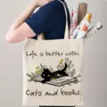 Bolso tote de lona casual con estampado de gato negro y libros, ideal para compras diarias. - Blanco Roto