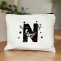 Detailopname van witte canvas cosmetische tas met grappige cartoon letter N opdruk. - Letter N Stijl