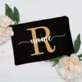 Detail shot of custom black canvas makeup pouch with gold letter R and white name print. - Letter R