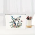 Detail view of the elegant canvas makeup bag featuring floral letter V design and smooth zipper. - Letter V