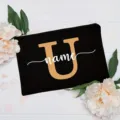 Close-up of black canvas cosmetic bag with customizable letter and floral background. - Letter U