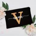 Black canvas makeup pouch with custom gold letter V and white name print for women. - Letter V