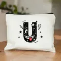 Close-up van witte canvas cosmetische tas met grappige cartoon letter U print. - Letter U Stijl
