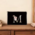 Elegant black canvas cosmetic bag with gold custom floral letter M detail for women. - M