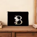 Black cosmetic pouch featuring a elegant gold letter B and floral print, detailed close-up. - Letter B