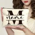 Custom canvas makeup bag detail shot showing personalized letter print and zipper closure. - M