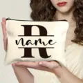 Closeup detail of custom canvas makeup bag featuring monogram letter and secure zipper closure. - Letter R