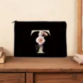 Detailed view of black cosmetic pouch featuring golden letter T and floral design. - Letter T