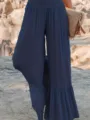 Detail view of women's navy blue pleated wide-leg pants featuring high waist and cute ruffles. - Navy Blue