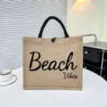 Elegante bolso tote de yute con asas negras y estampado Beach Vibes para uso diario. - Estilo Impreso Beach Vibes Caqui (1)