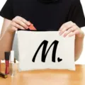 Custom white canvas zipper makeup bag with black letter print for travel cosmetics storage. - Style M