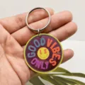 Acrylic keychain detail showing glossy mirror finish, colorful typography and sturdy metal ring. - Purple