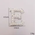Nahaufnahme des Strass-Perlen-Buchstaben E Aufnähers, glänzendes DIY Bekleidungszubehör. - Buchstabe E