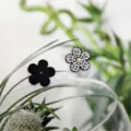 Close-up of DIY black and rhinestone flower shoe charms and clothing patches for accessories. - Flower